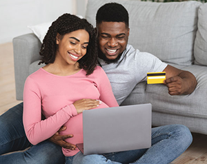 A young couple shopping online for their new baby.